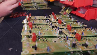 Hands inserting electronic component into printed circuit board - close up