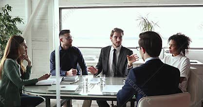 Happy multiracial management making agreement with client indoors.