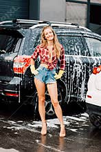Girl standing with hands on hips near autos in car wash