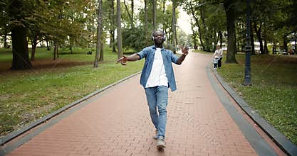 Happy Dancing Afro-American in Earphones in Park