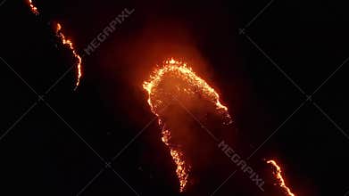 Aerial view. Night fire. On the field burning dry grass. 4K.