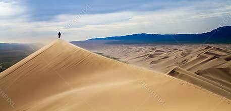Men walking in the mongolian desert sand dunes. Young men walking golden sand on a bright summer day, Mongolia holliday