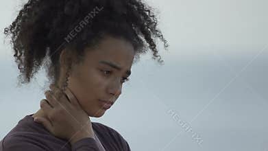 Depressed African-American teen girl standing alone, awkward age problems