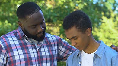 African-american father trying to comfort unhappy son, family support, trust