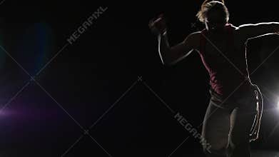Slow motion. Close-up female practicing capoeira in darkness
