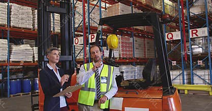 Male and female warehouse managers talking in a warehouse loading bay 4k