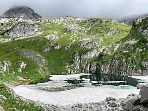 Abkhazia, lake Dzou in the mountains in summer in cloudy weather