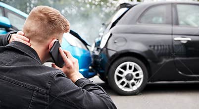 Young Male Motorist Involved In Car Accident Calling Insurance Company Or Recovery Service