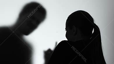 Crying woman looking scolding male shadow, aggressive husband behavior, divorce