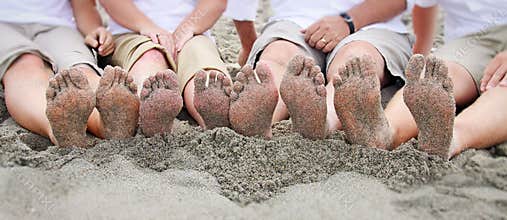 Family feet on beach in line