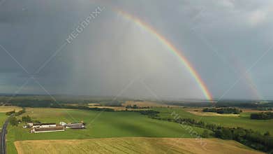 Rainbow Above Wheat Field.  Ripe Crop Field After Rain and Colorfull Rainbow in Background Rural Countryside. Aereal Dron Shoot.