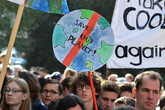 Round protest sign in the shape of planet earth saying `Save our planet` held up by young people during Global Climate Strike even