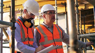 Construction engineer is giving instructions to his colleague