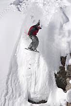 Snowboard jump from a cliff in the powder