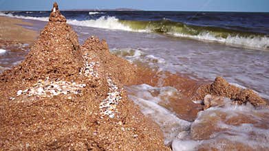 Wave breaks wall of sand the castle