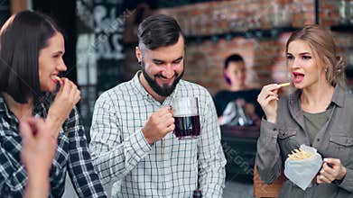 Young people have fun laughing talking enjoying weekend party at cozy loft restaurant interior