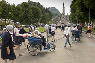 Lourdes, France June 24, 2019: Volunteers helping the sick get to the sanctuary of Our Lady in Lourdes