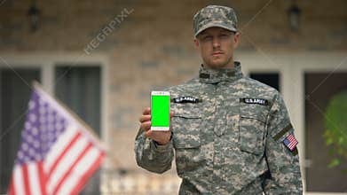 Soldier showing phone with green screen, veterans psychological support online