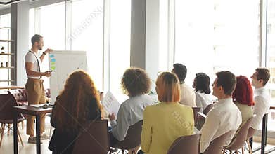 Corporate employees gathered at the conference hall watching product presentation and making notes