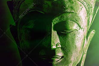 Spiritual enlightenment. Green buddha face statue close-up. Bold graphic image