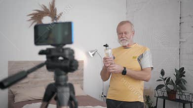 Old man Influencers blogging on healthy lifestyle content recording exercises on phone camera during a live broadcast