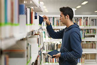 Man choosing book in library