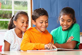 Three primary school children reading and learning