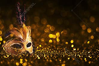 Luxury venetian mask on dark godlen bokeh background. New year and christmas party celebration design banner