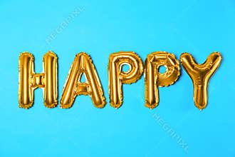 Word HAPPY made of golden foil balloon letters on blue background