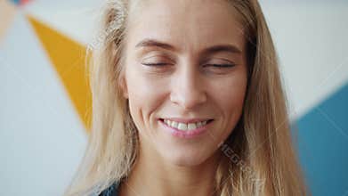 Close-up portrait of unique girl with blue eyes and blond hair smiling indoors