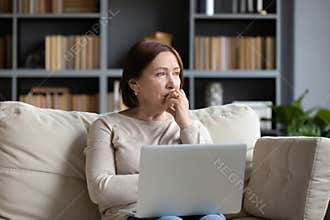 Pensive middle-aged woman look in distance pondering