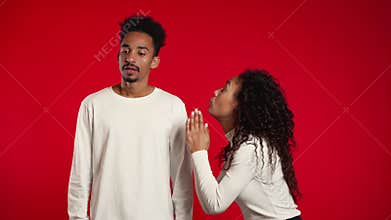Cute african young woman begging her boyfriend or husband about something over red background.