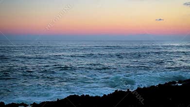 Beauty calm view of the ocean at sunset from coral rocks.