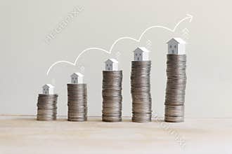 The coins that are stacked in a graph with home on top and growing arrow symbol.