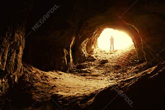 Man standing in front of a cave entrance