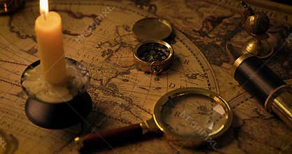 Exploration concept - antique objects on old world map in candlelight