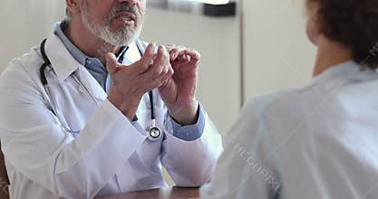 Old male doctor handshaking healthy female patient, close up view