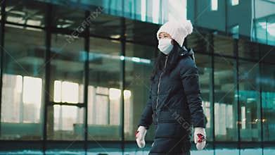 Woman walks in empty street, wears mask at quarantine. Coronavirus epidemic.