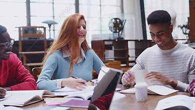 Happy college students studying together