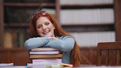 Happy young woman on books