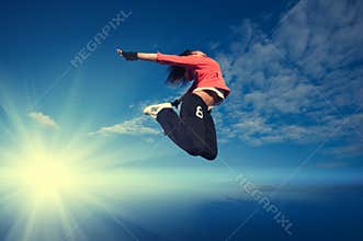 Sport woman jumping and fly over sky and sun