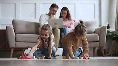 Young couple web surfing internet, little kids daughters having fun