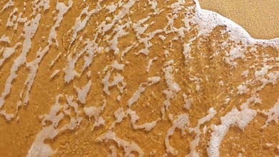 Word chill painted at the sand is washed off by the wave