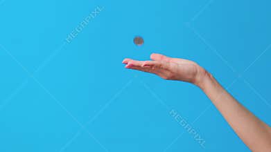 Hand throw coin on blue background