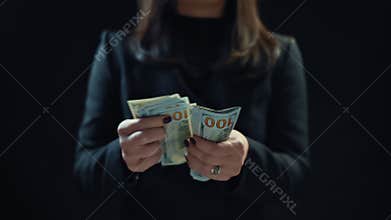 Close up, young woman businessman is counting money, on black background. 4k