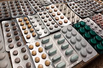 Closeup shot of different pills on table with tablets , pharmaceutical industry concept