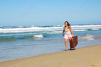 Woman with suitcase on beach