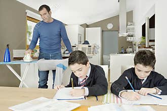 Kids doing homework, dad ironing.