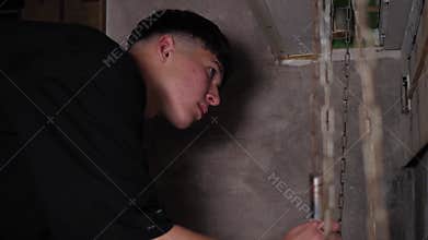 A guy moving chains with weights up and down performing a task in the quest room