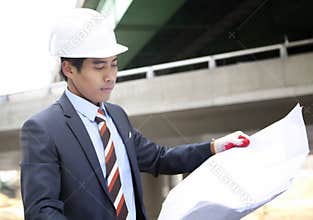 Asian architect on highway construction site